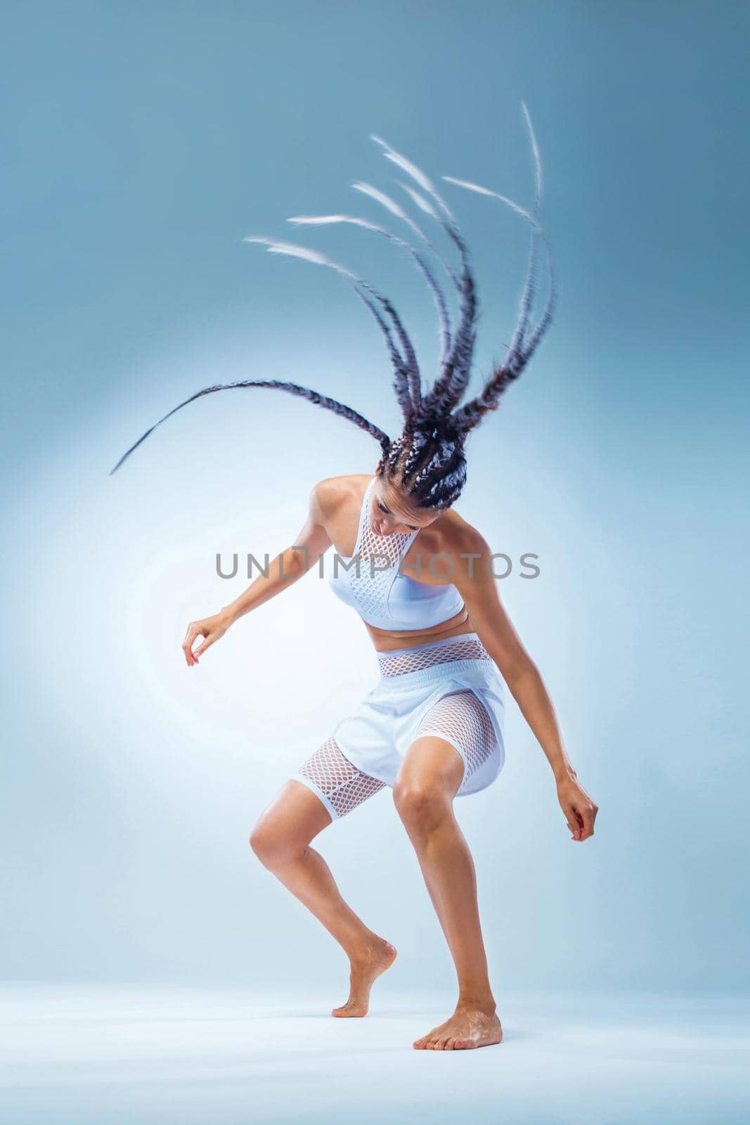 Attractive excited fitness girl in sportwear jumping of joy isolated over light background