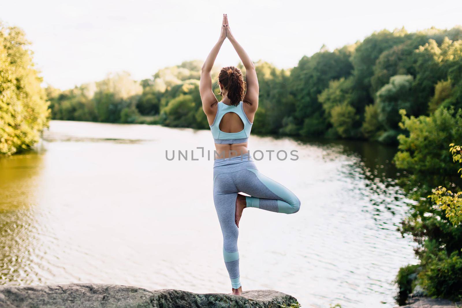 Pretty woman doing yoga exercises in the park by OnPhotoUa