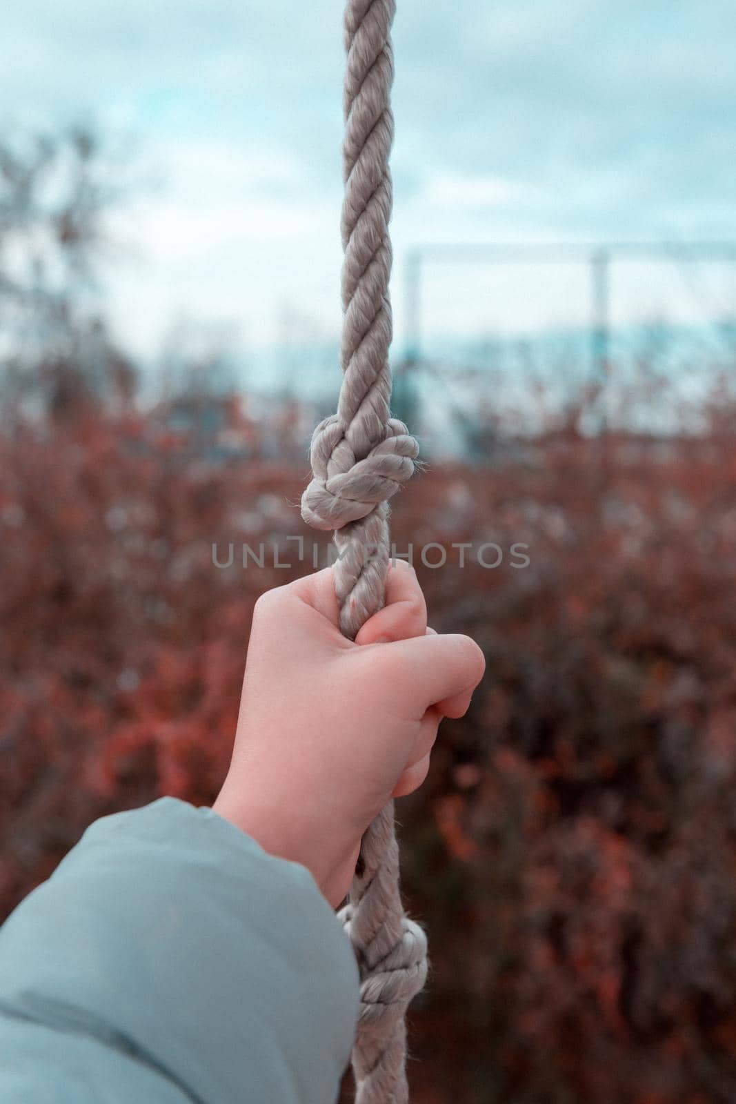 Woman hand holding the rope. Girl hand clinging to the rope, closeup by lunarts