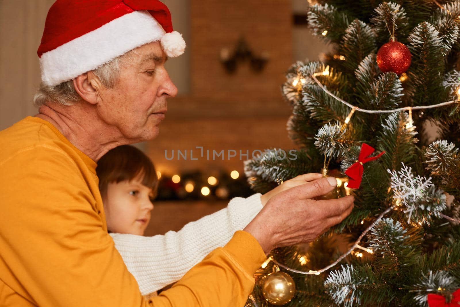 Grandfather and granddaughter in festive room decorating fir tree, little female kid with mature man celebrating new year eve together, merry christmas. by sementsovalesia