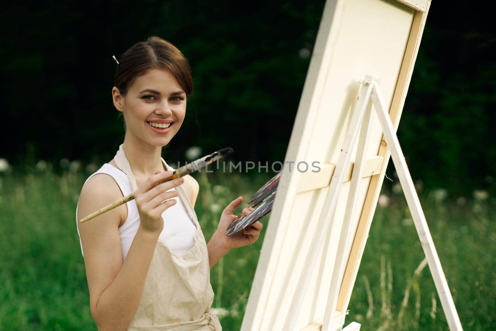 cheerful woman artist painting a picture outdoors creative art. High quality photo