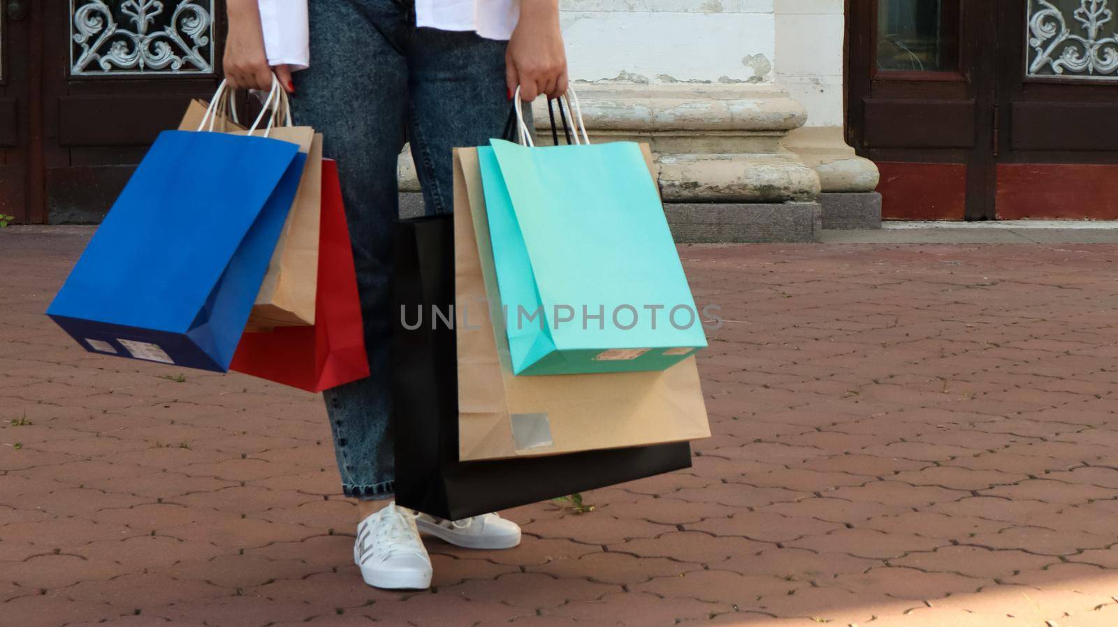 Shopaholic woman with paper shopping bags in her hands. Crop the photo. Consumerism, shopping, lifestyle concept. Copy space for your logo. shopping and sales season concept. Black friday thursday.