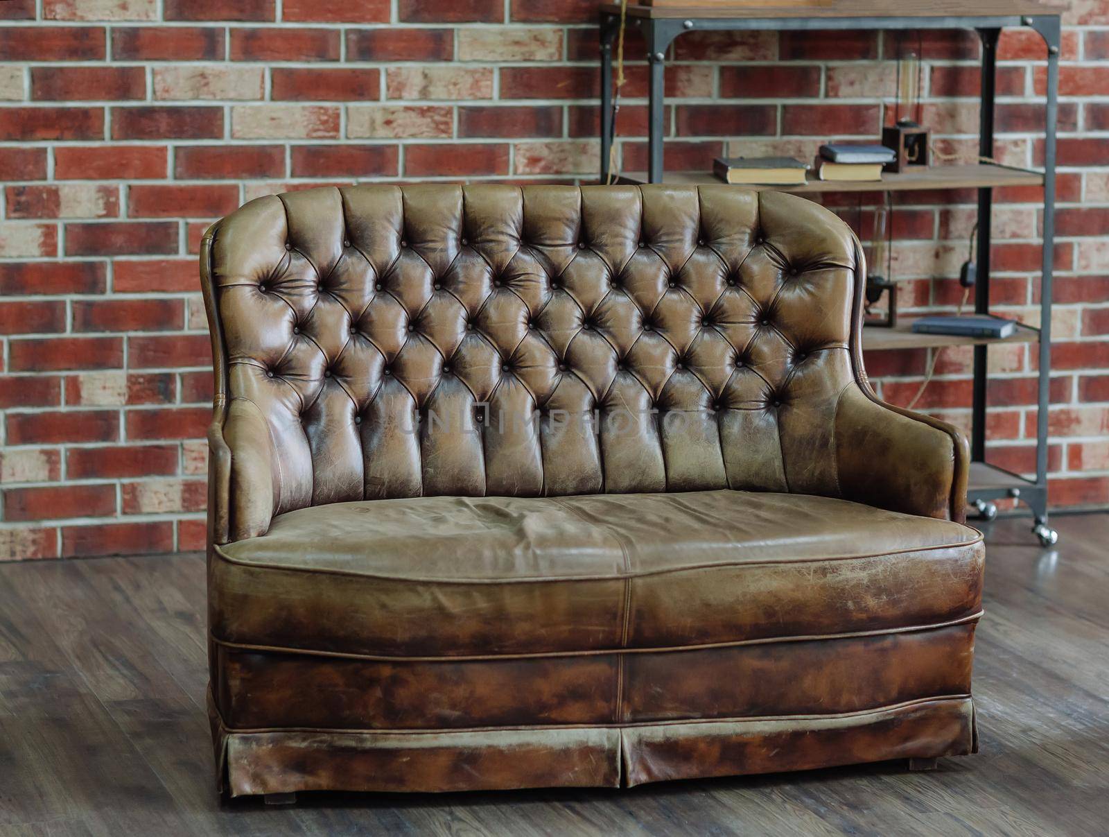 Retro sitting room with leather couch and brick background wall, loft interior