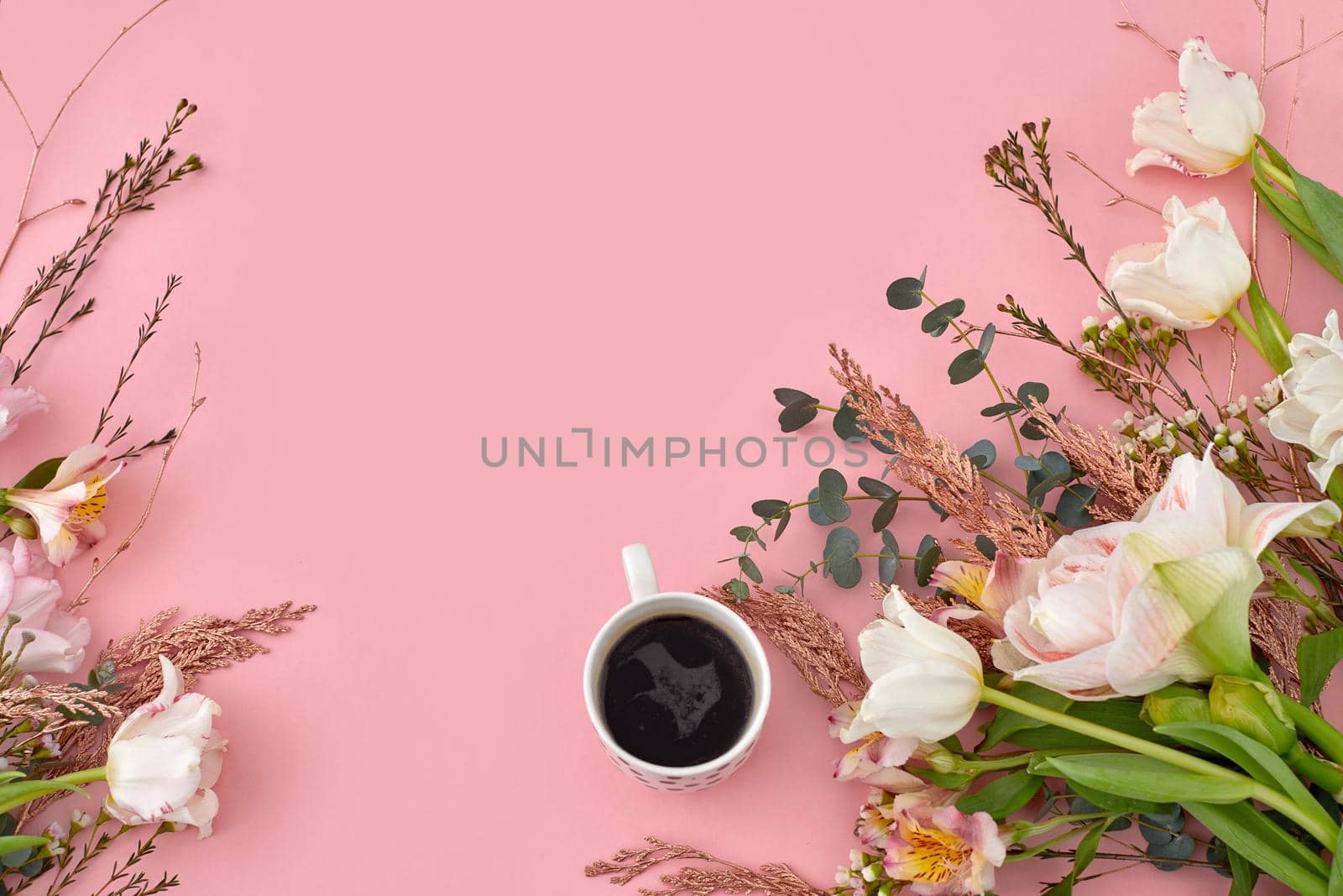 White cup of coffee with tulip on pink background copy space