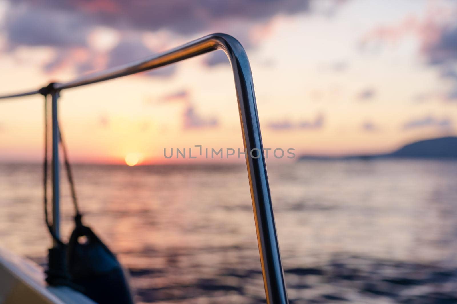 Deck of white yacht sailing in open sea at sunset, close up