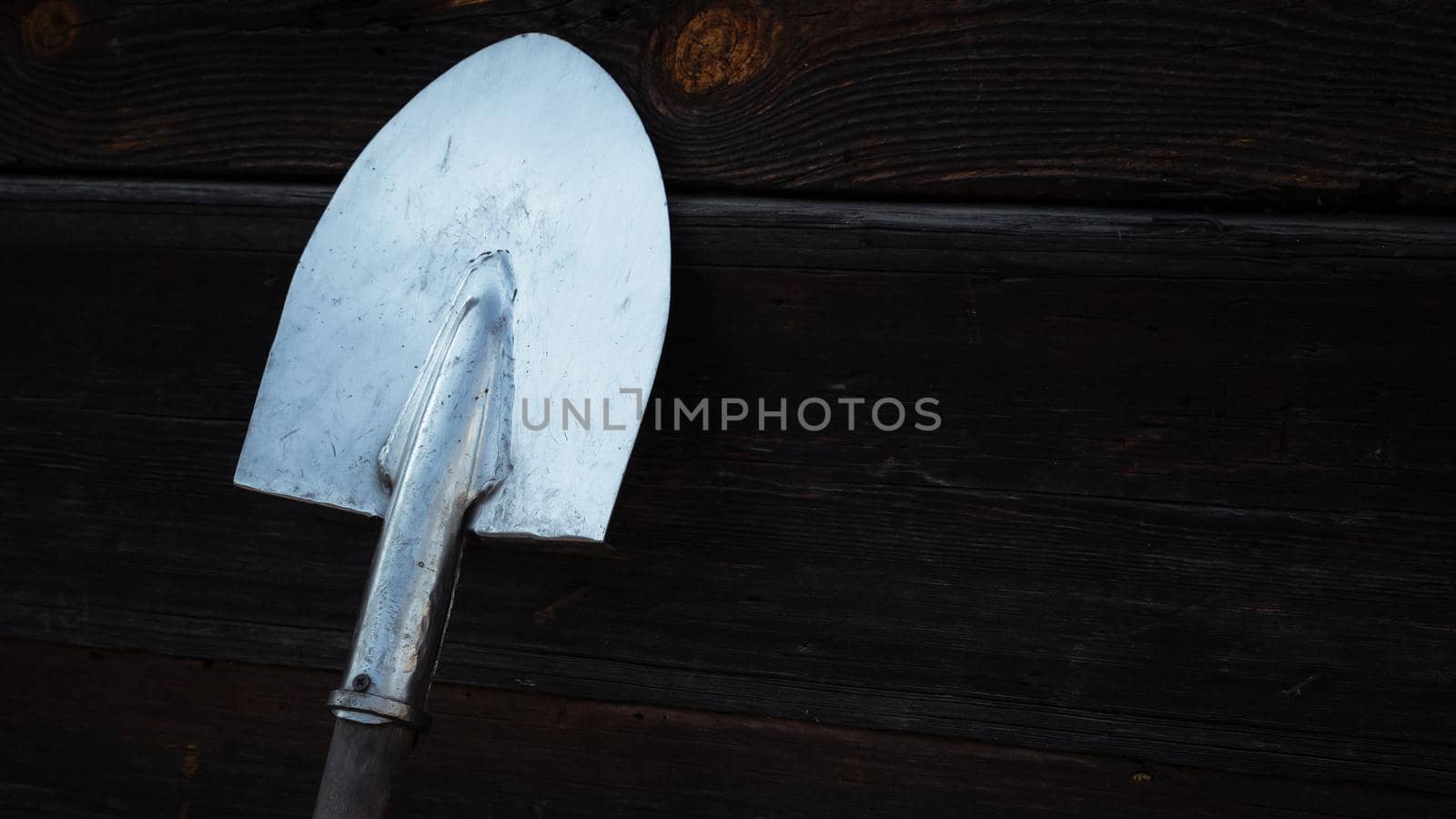 Old rusty shovel prop up against Old wooden wall, Wooden texture background.