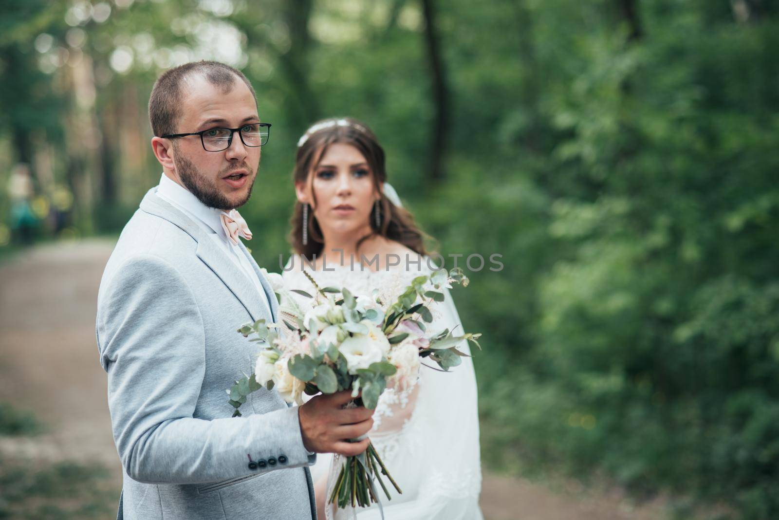 Wedding photo of the bride and groom in a gray-pink color on nature in the forest and rocks. by lunarts