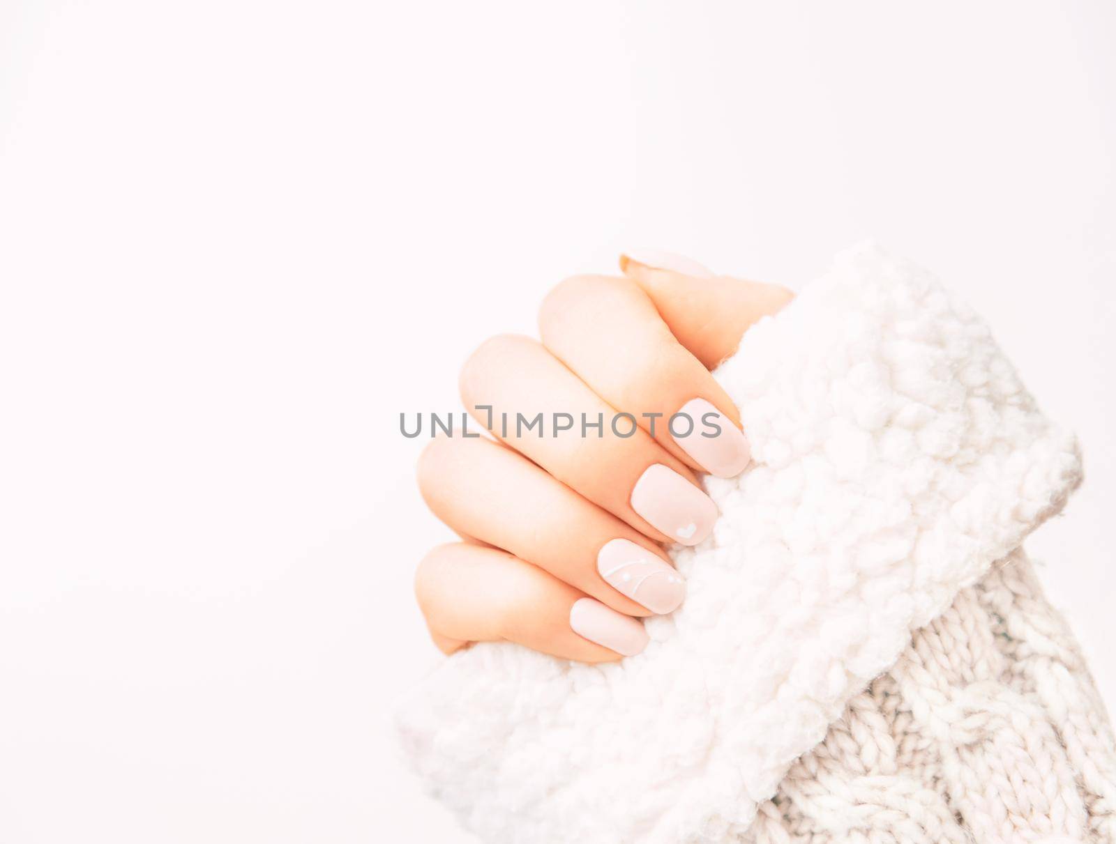 Female hand with professional manicure wearing in wool sweater. by alexAleksei