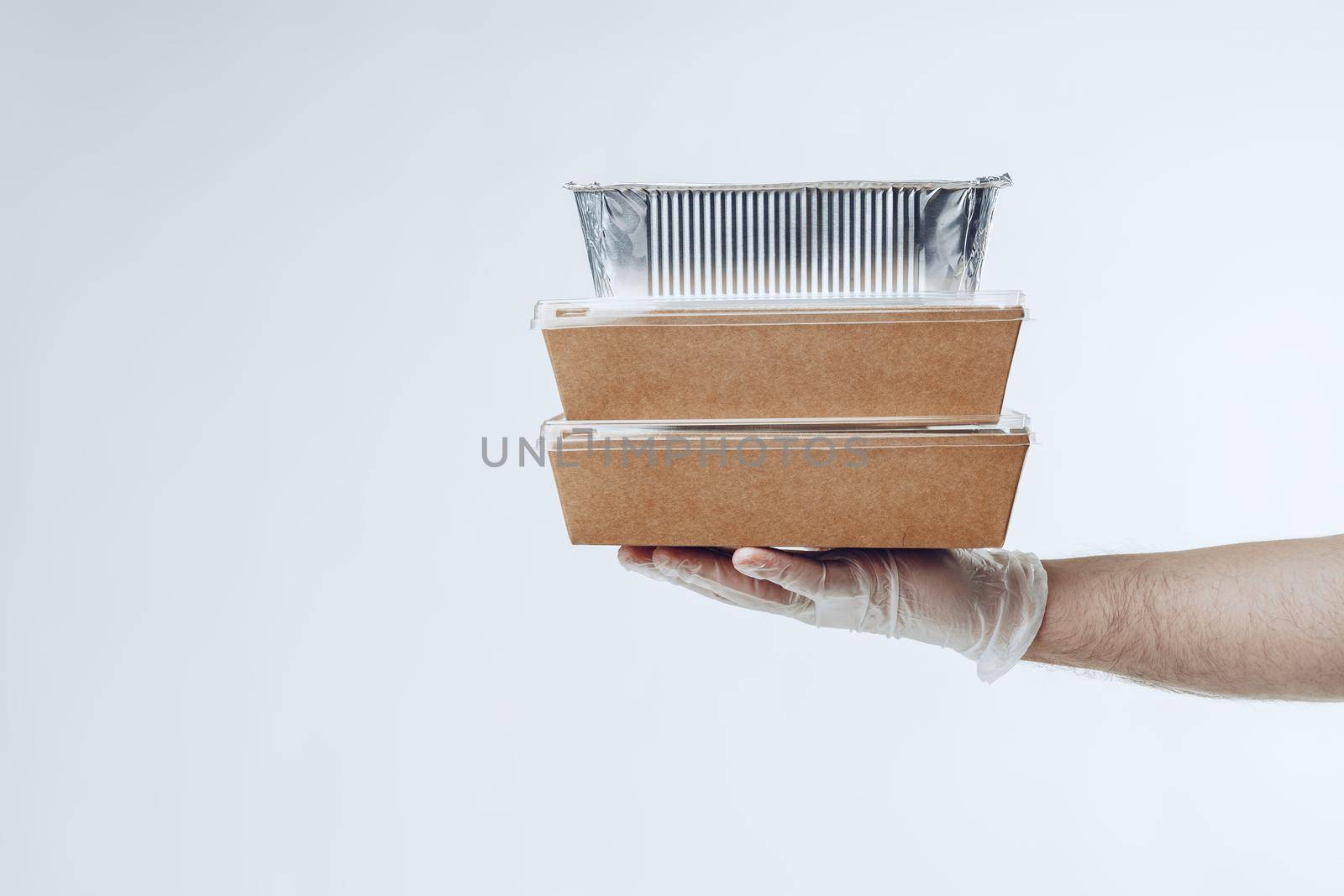 Courier hands in latex gloves giving packed food delivery close up