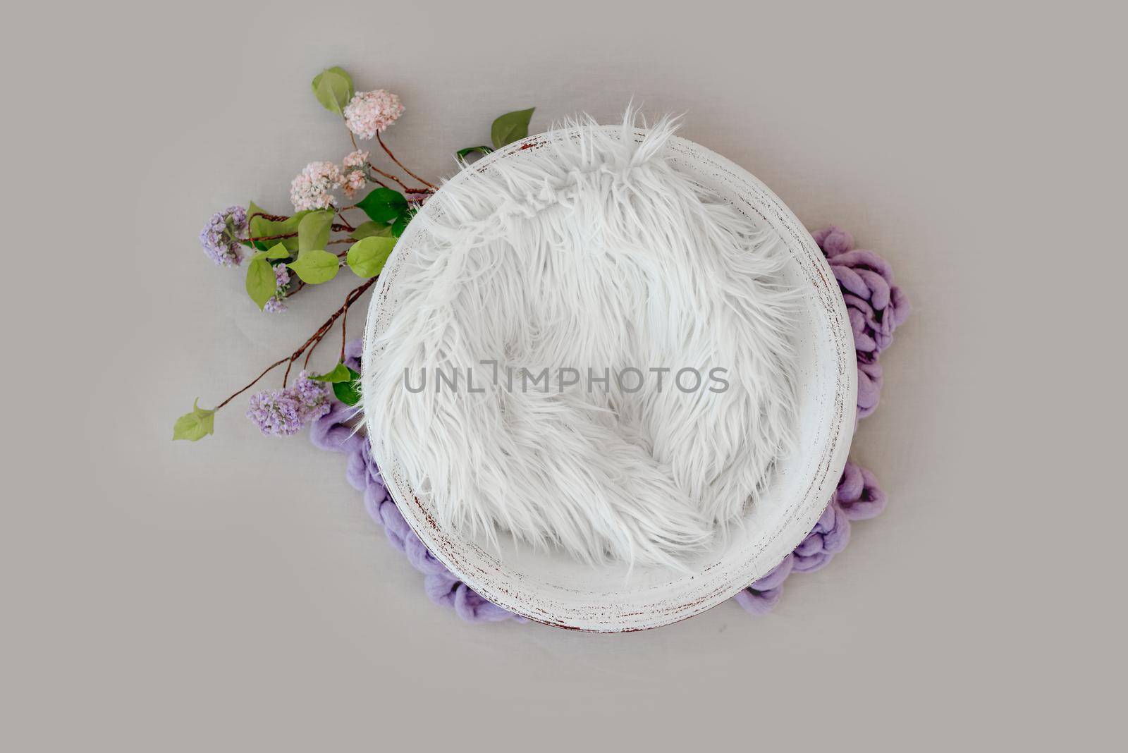 Beautiful backdrop for newborn photosession with flowers hydrangea. Digital composite with basin filled with knitted blanket isolated on light pink background