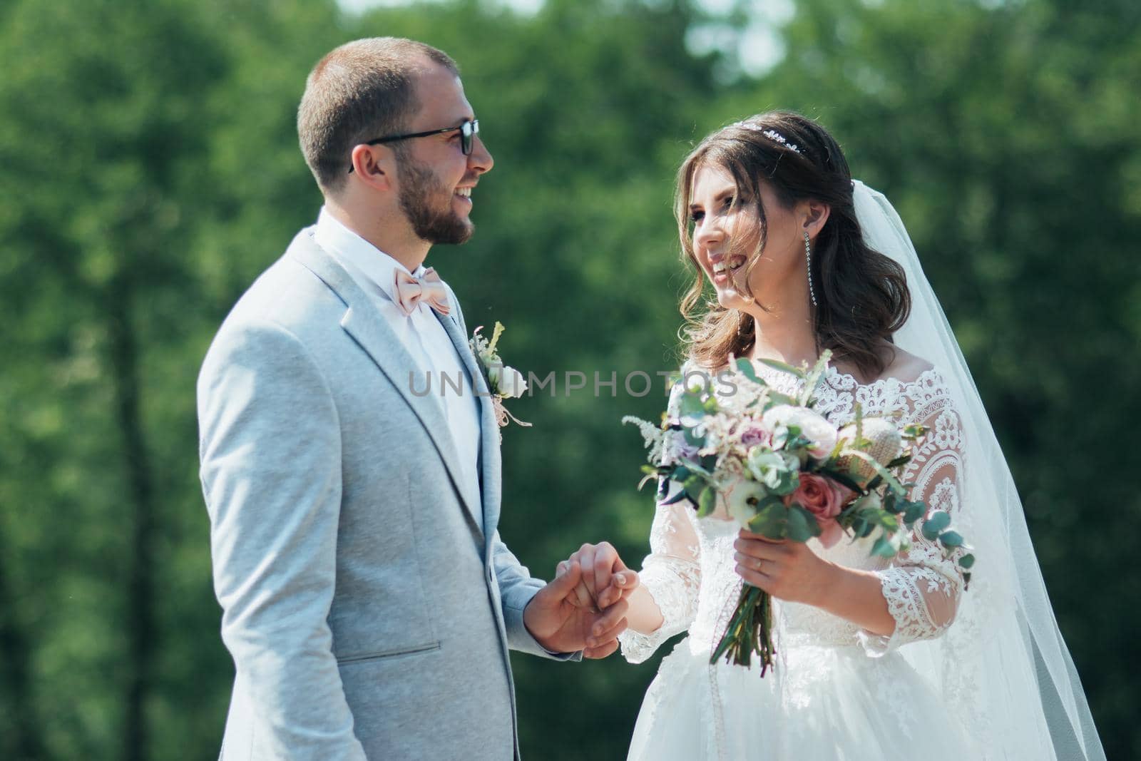 Wedding photo of the bride and groom in a gray-pink color on nature in the forest and rocks. by lunarts