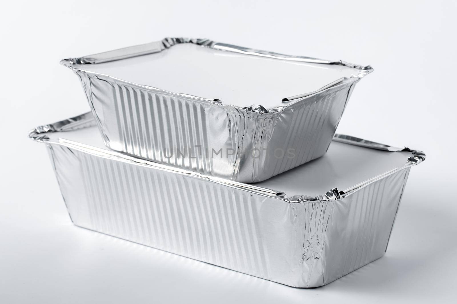 Foil food box with takeaway meal on white background close up