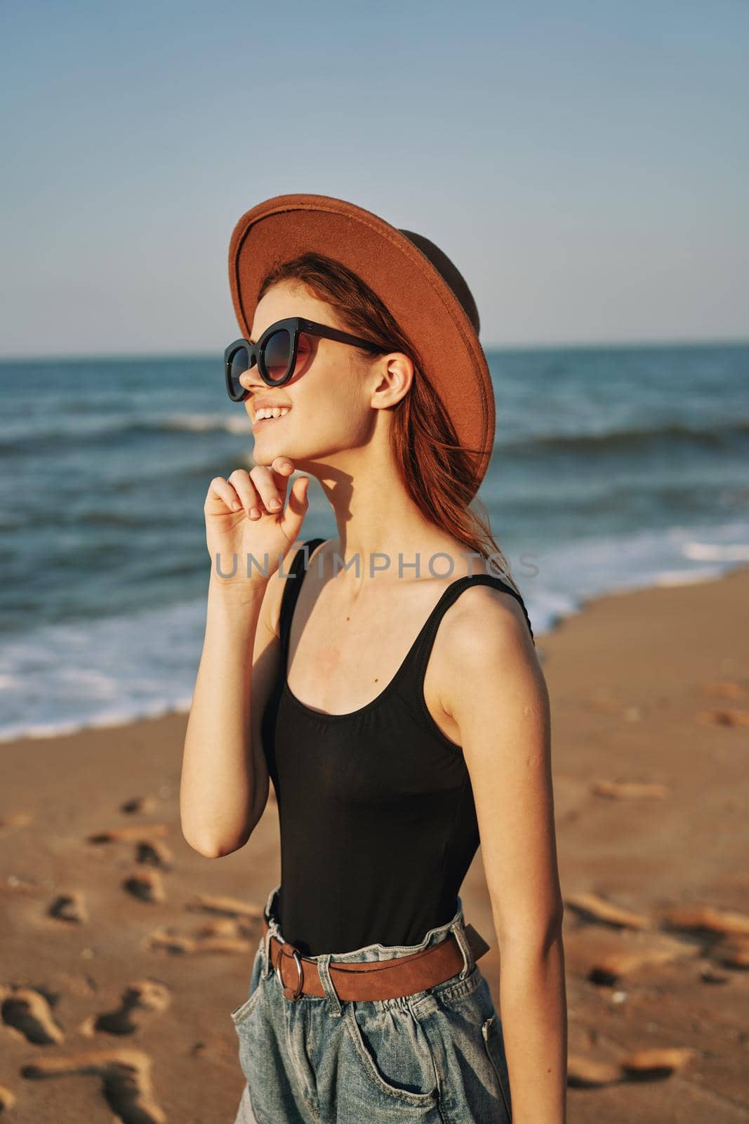 pretty woman in hat and sunglasses on the beach walk sun. High quality photo