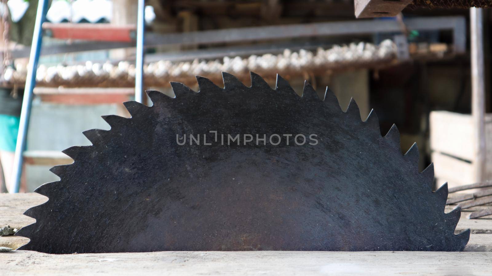 Old circular saw on wooden background with daylight. Carpentry work. Plunge saw blade for wood close up.