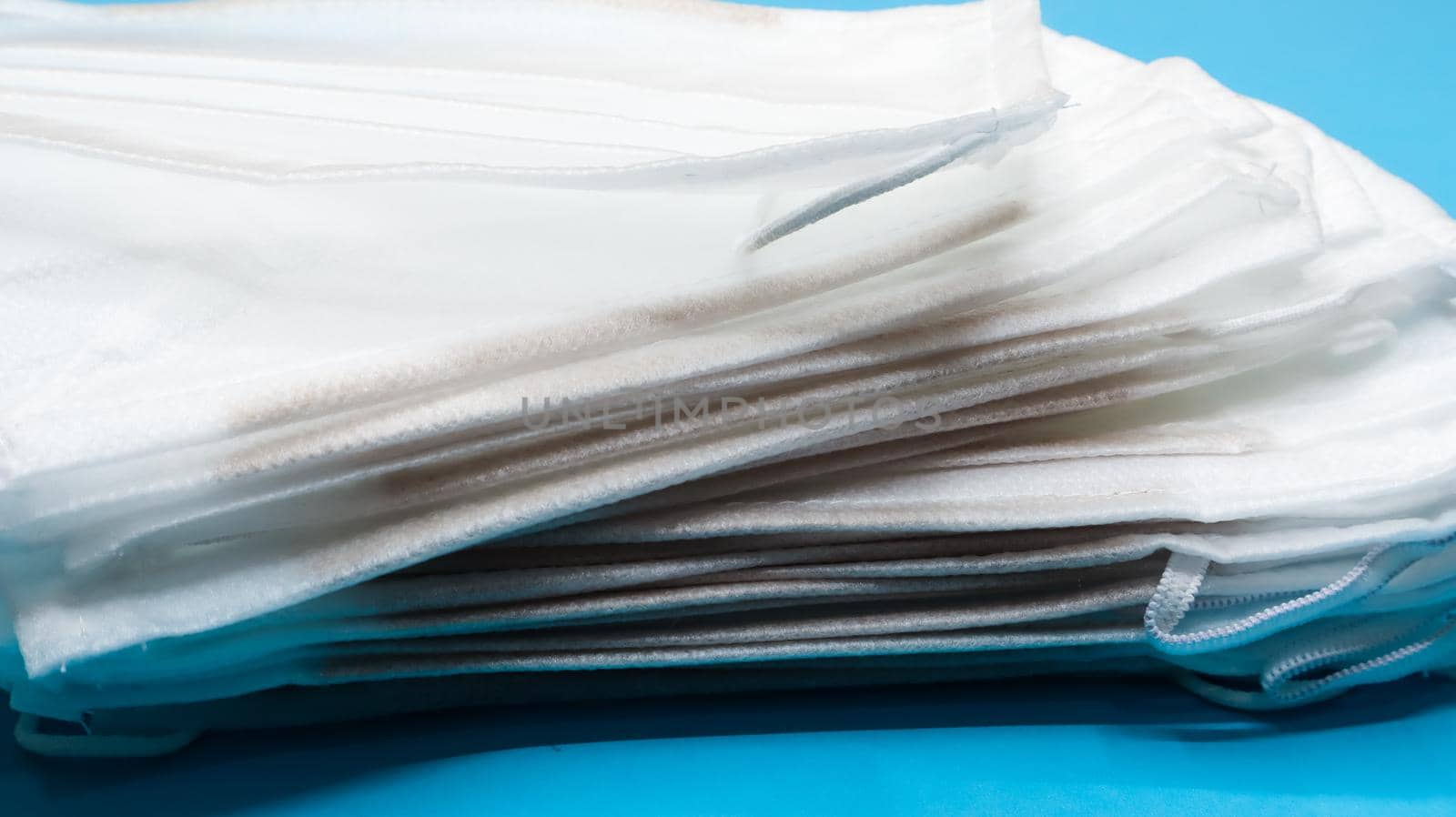 Coronavirus protection. Antiviral protective medical face masks with ear loops. Surgical mask background. Respiratory syndrome, coronavirus disease COVID-19. Many folded medical masks