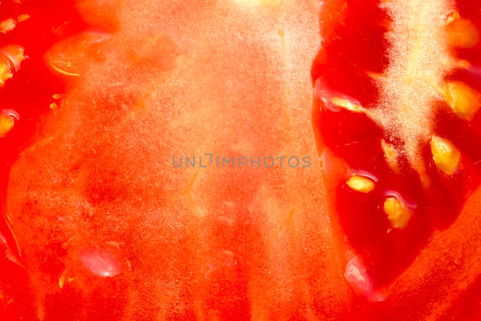 Slice of red tomato as background. Close-up