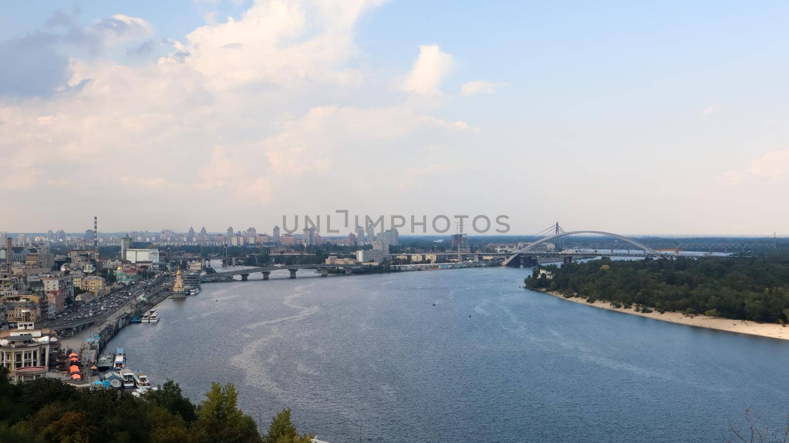 Top view of the old historical part of the city of Kiev. Vozdvizhenka area on Podol and the Dnieper river from the pedestrian bridge. Beautiful city landscape. Ukraine, Kiev - September 6, 2020