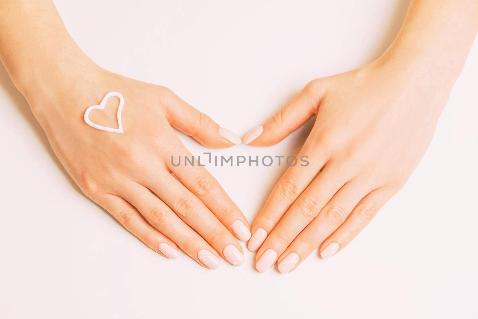 Female hands with manicure making heart shape gesture. by alexAleksei