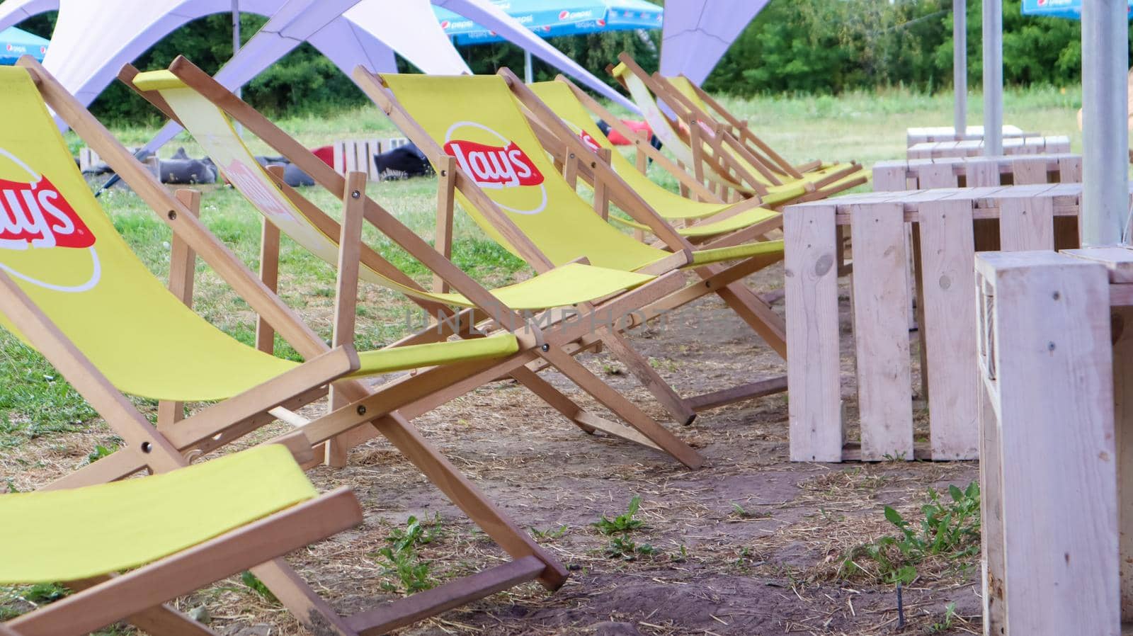 Yellow chairs in a cafe with the Lais logo in the summer. Urban marketing branding. a brand of potato chips produced since 1938. Since 1965 it is owned by PepsiCo.Ukraine, Kyiv - September 6, 2020