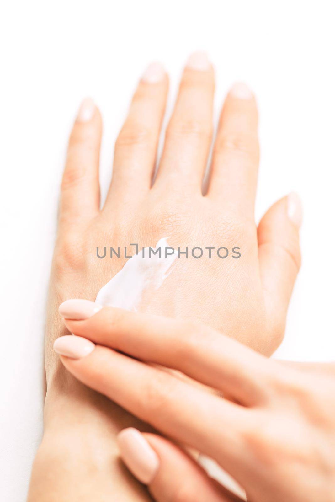 Young woman’s hands applying moisturizing cream for smooth skin, concept of skincare and beauty. Point of view image.