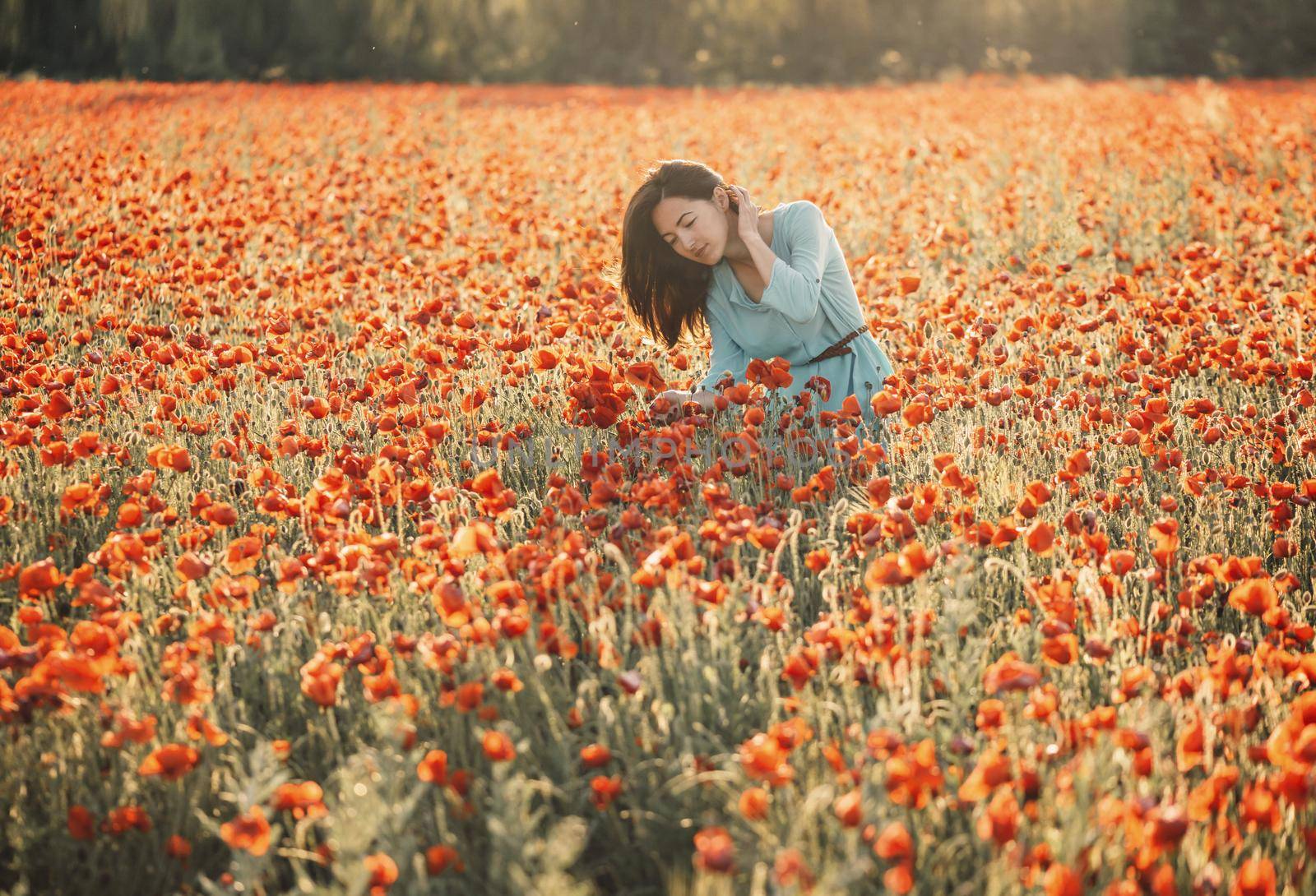 Romantic young woman walking in flower field. by alexAleksei