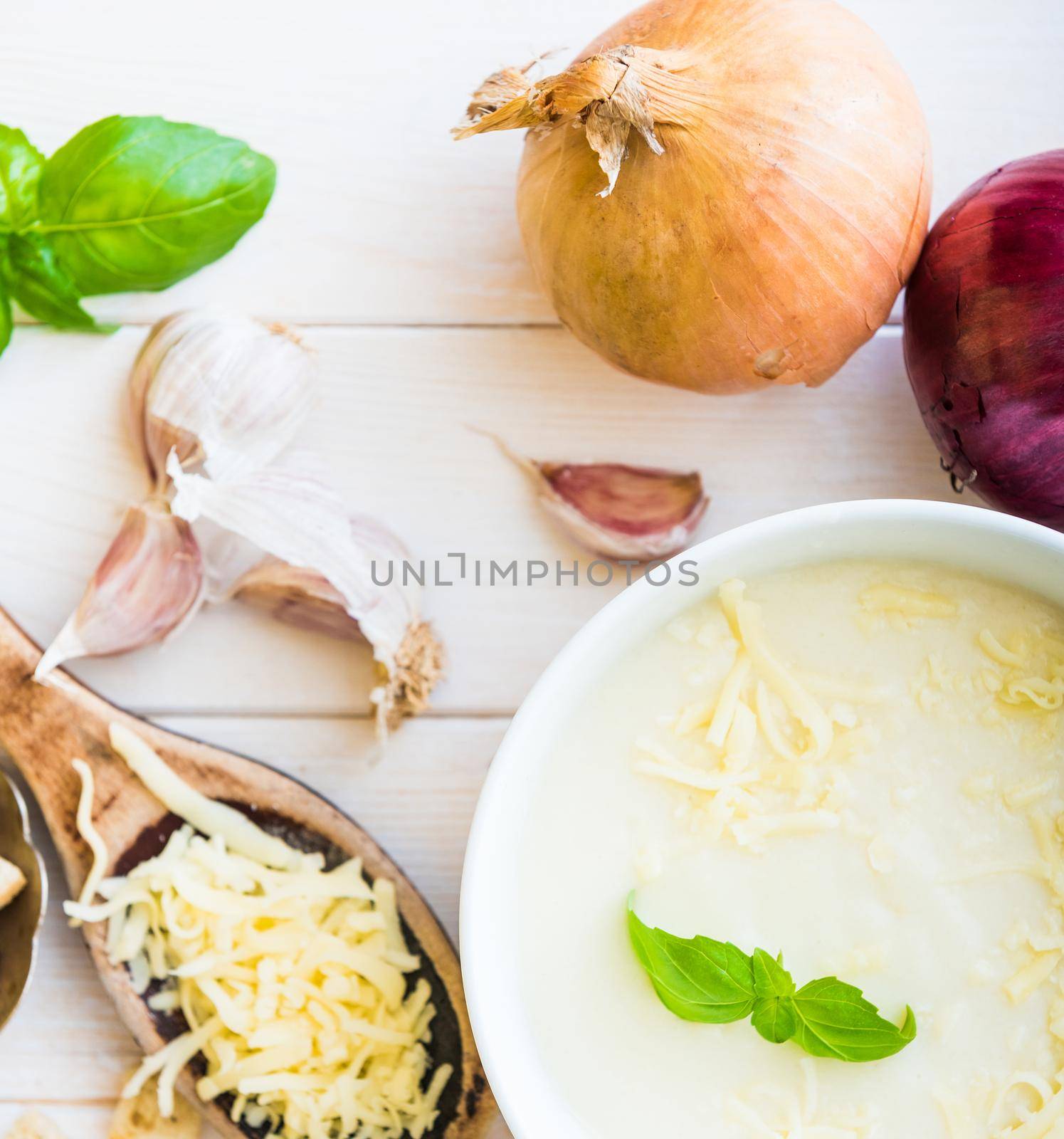 onion soup puree in a white plate with toasts and cheese on the table