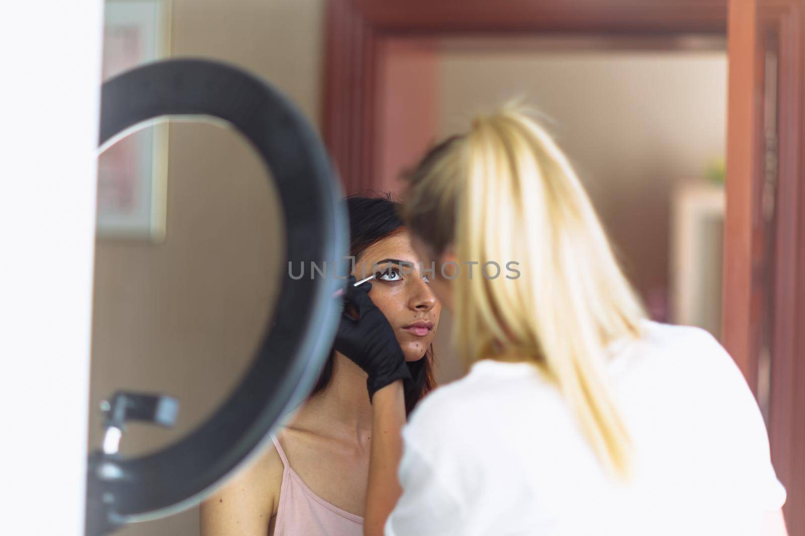 Makeup woman artist at work, professional in action with young model in beauty salon and creative classes