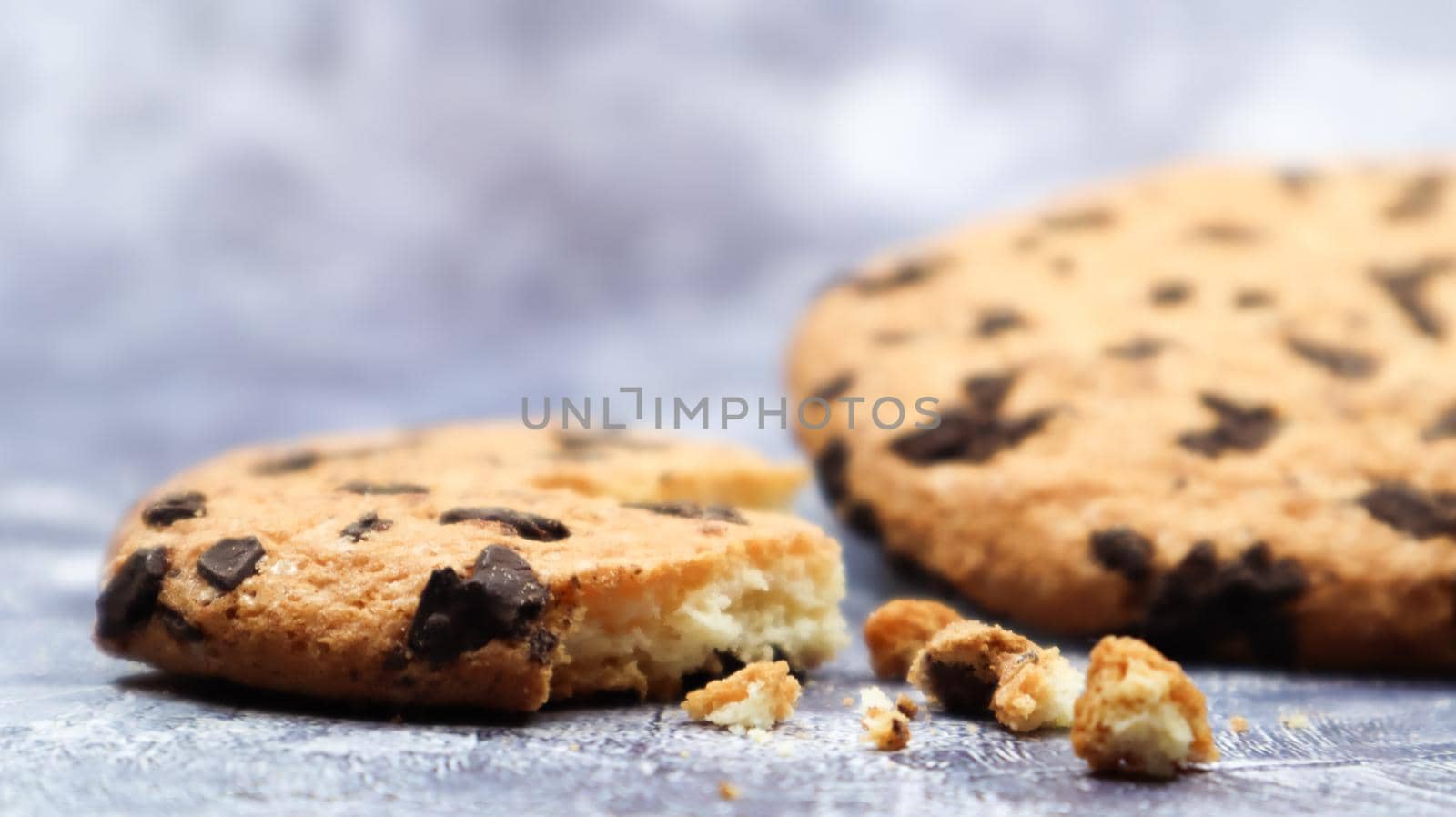 One soft, freshly baked chocolate chip cookie on a gray marble kitchen countertop. American traditional dessert. Delicious sweet food. Homemade baking concept for the holiday. Culinary background.