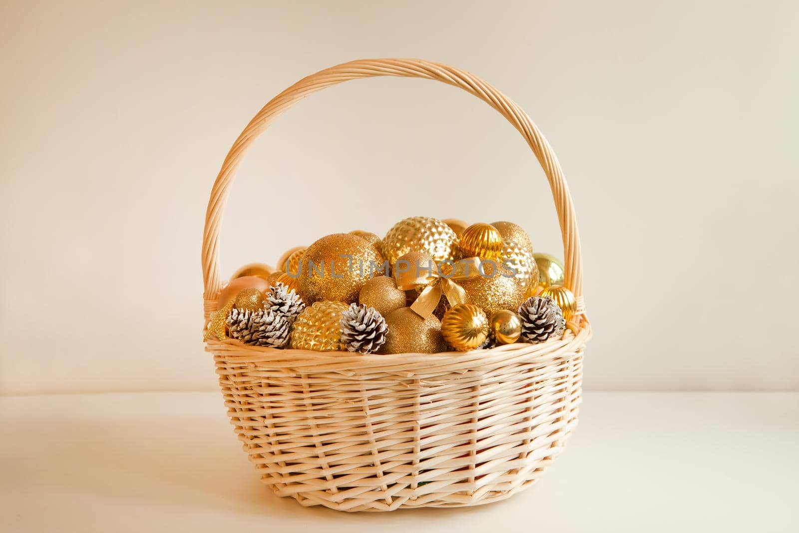 huge white basket with golden balls for fir decoration. Christmas preparations. wicker filled to the top with golden balls to decorate Christmas tree or apartment