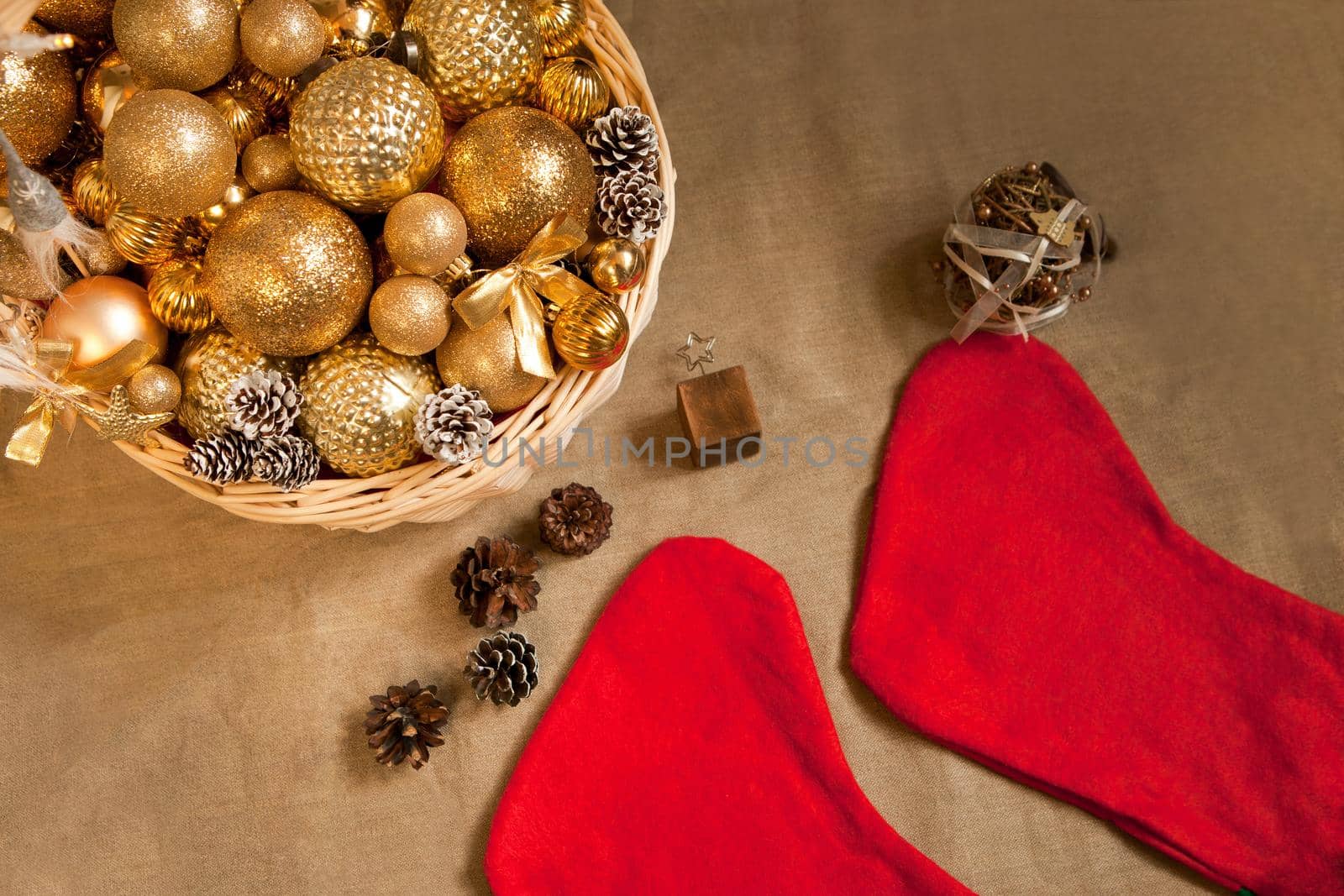 huge white basket filled with golden balls to the top for fir decoration and Christmas Holiday Socks. Christmas preparations, apartment decorations
