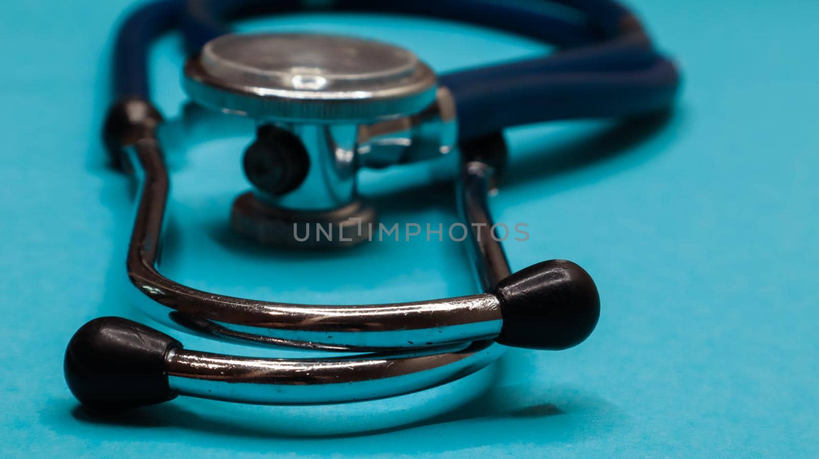 Old shabby stethoscope on a blue background