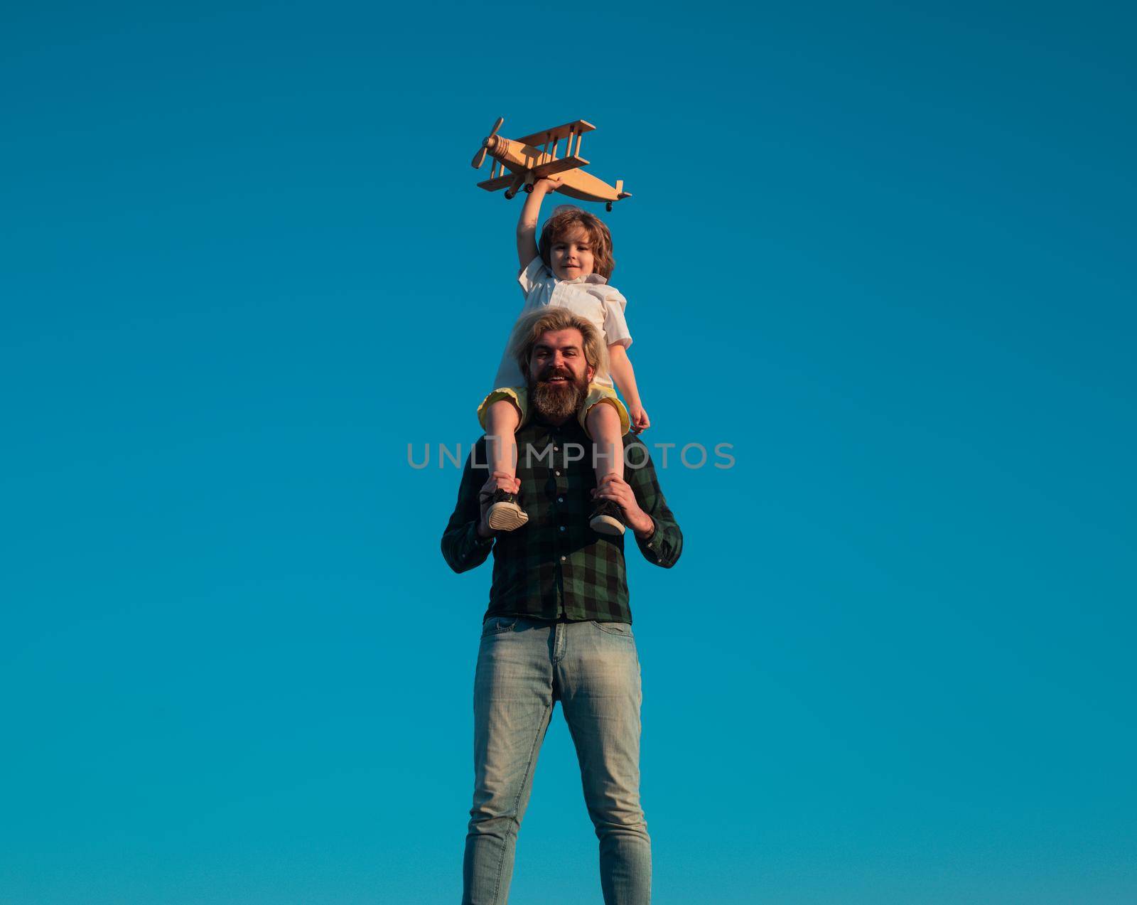 Father and son happy family. Boy sitting on fathers shoulders