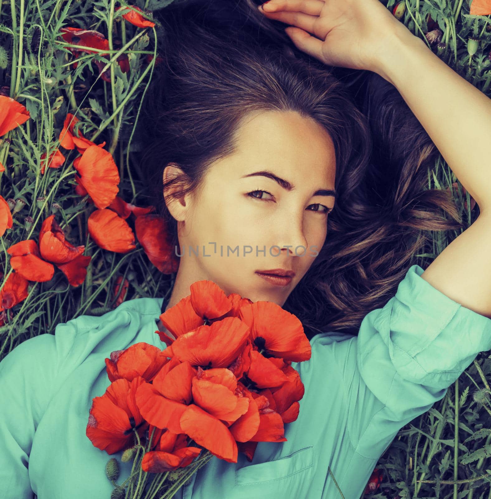 Outdoor portrait of attractive young woman with red poppy flowers, stylish and beauty concept.