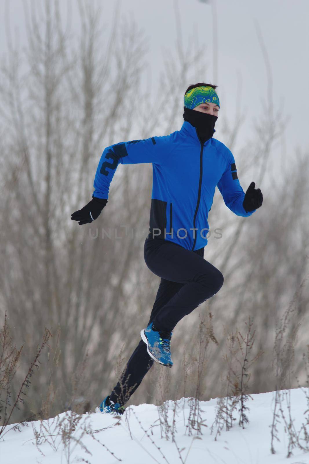 Male athlete running in winter by Studia72