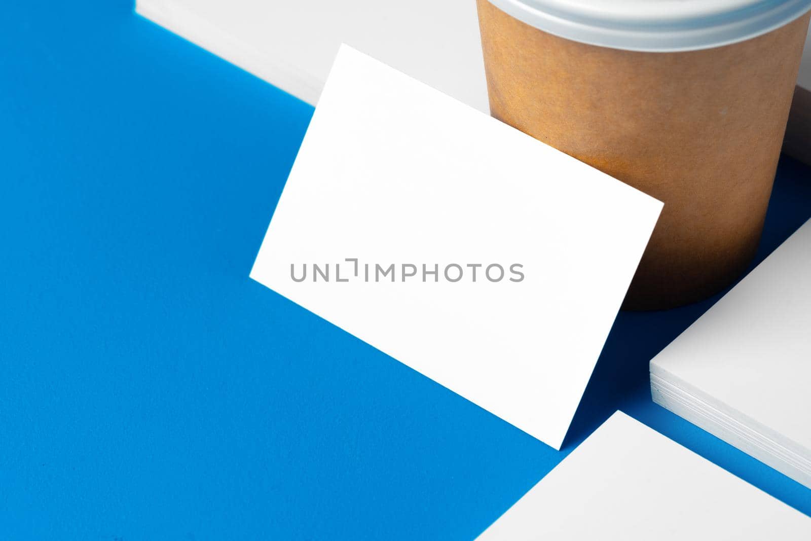 Blank takeaway coffee cup and white businesscards with copy space