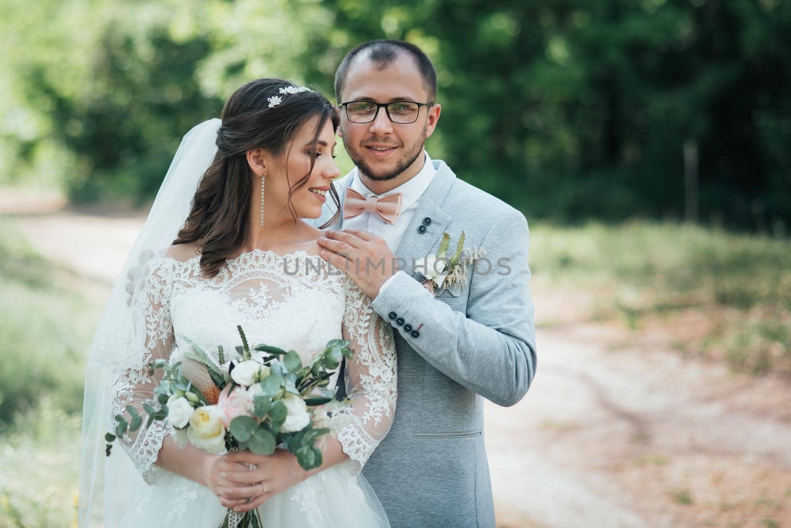 Wedding photo of the bride and groom in a gray-pink color on nature in the forest and rocks