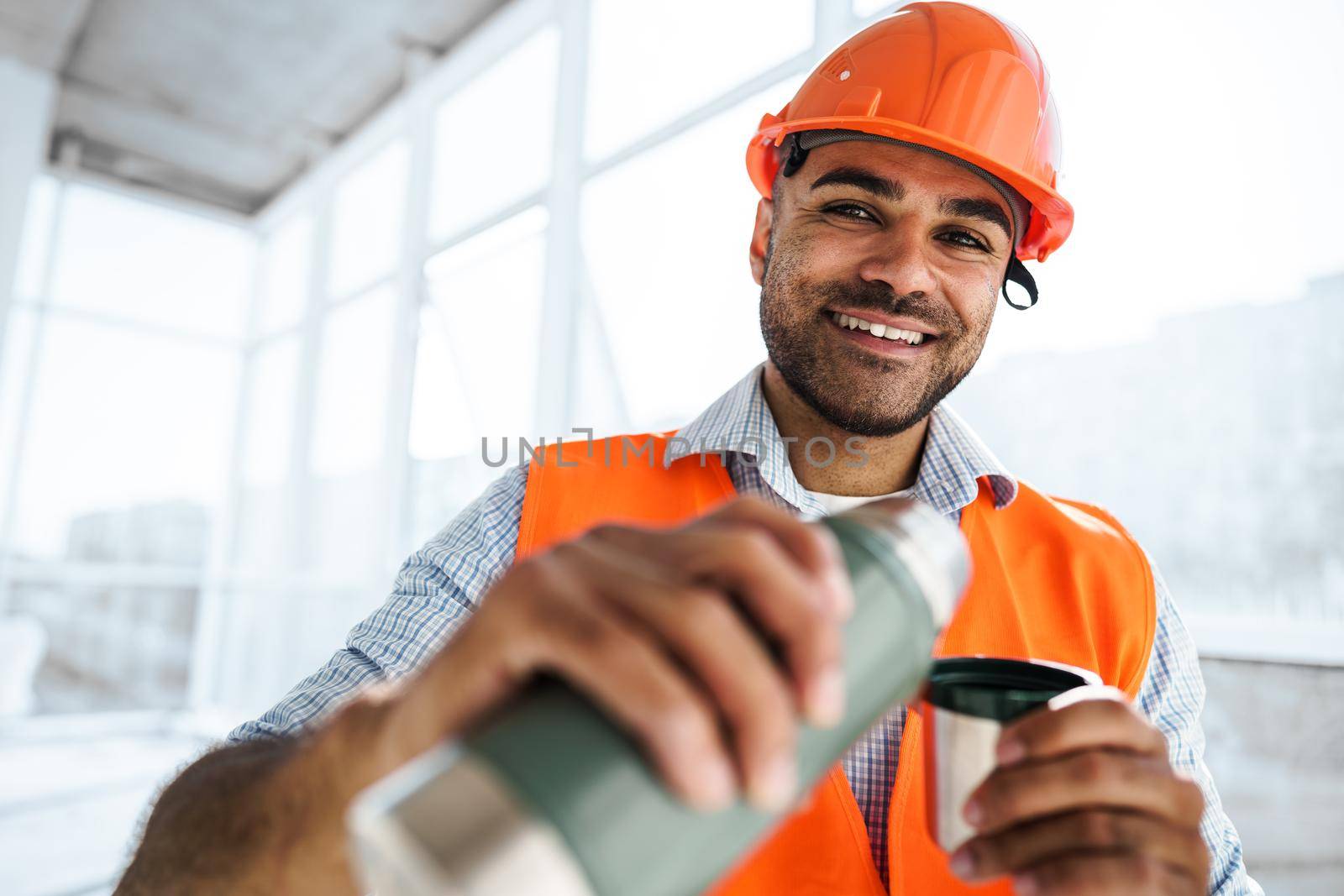 Portrait of a man worker in workwear on a break drink coffee and have rest, close up