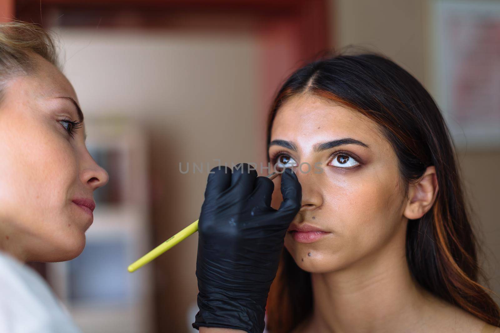 Makeup woman artist at work, professional in action with young model in beauty salon and creative classes