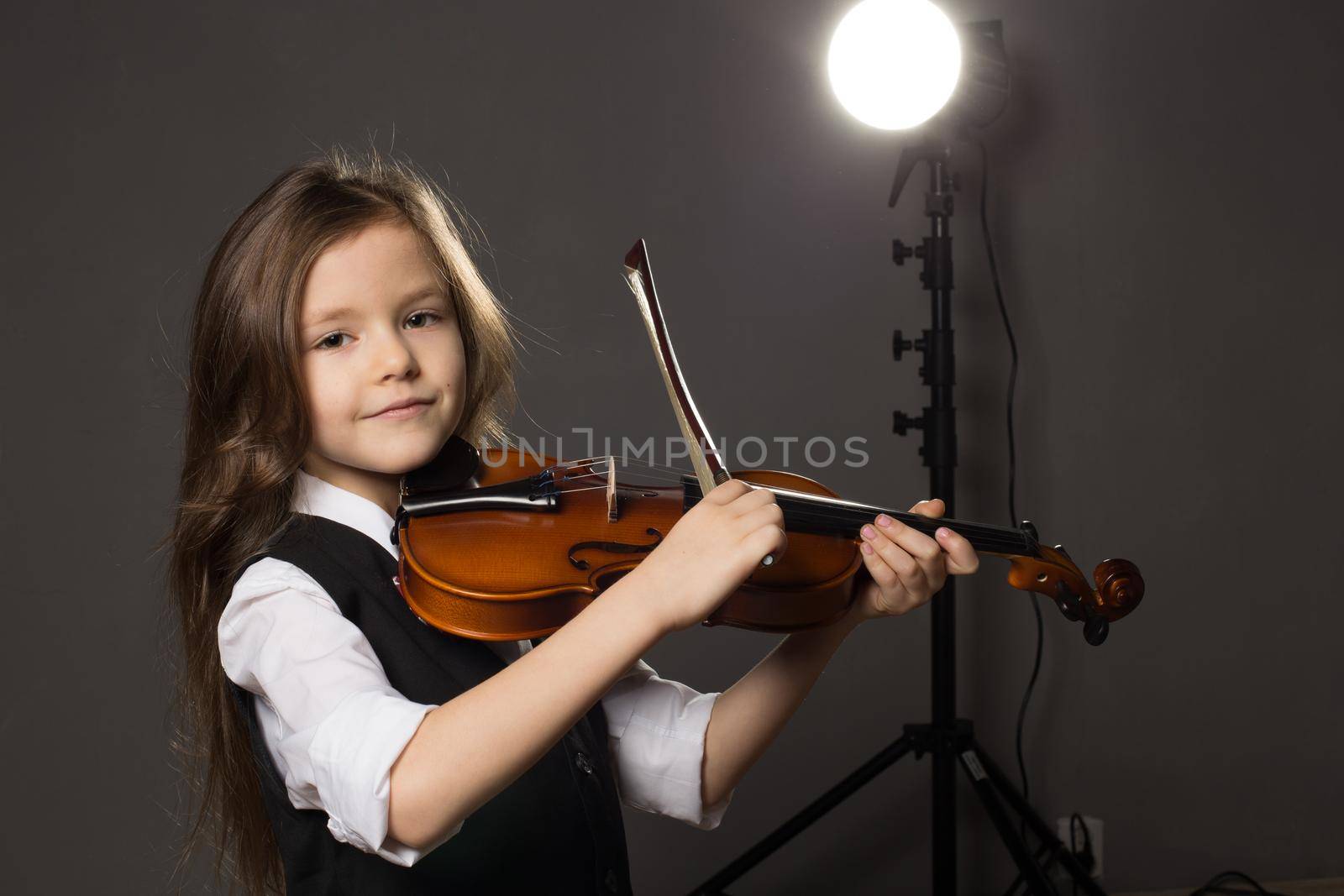 Beautiful girl with long hair playing violin