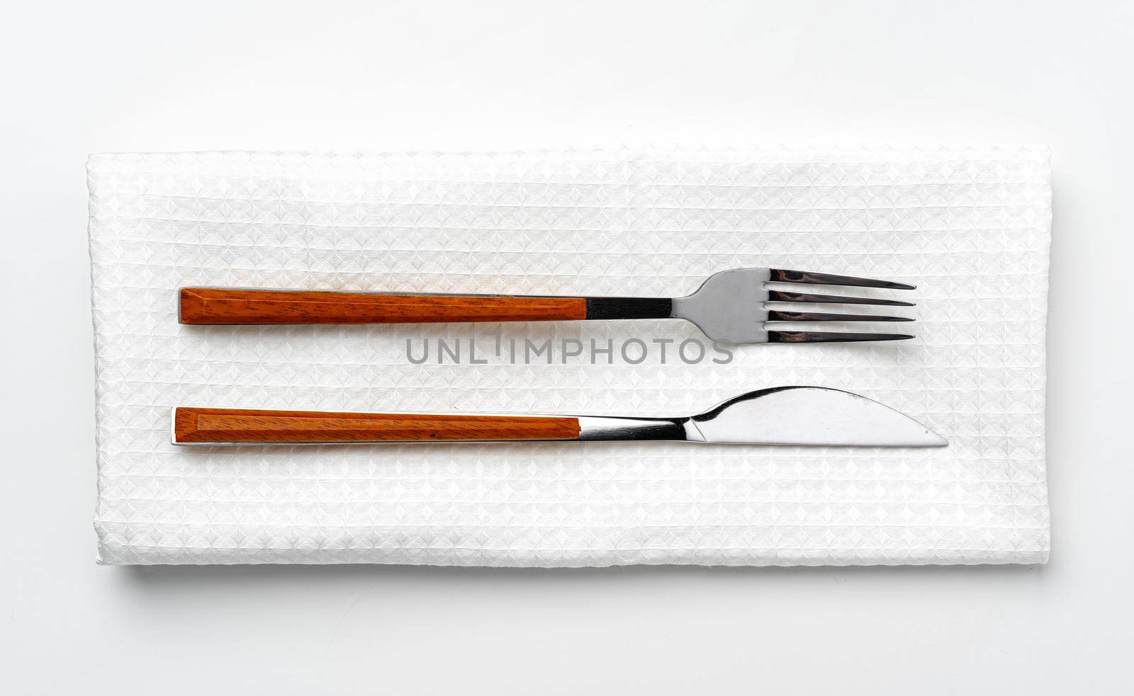 Set of fork and knife on towel. Isolated on white background. Close up.