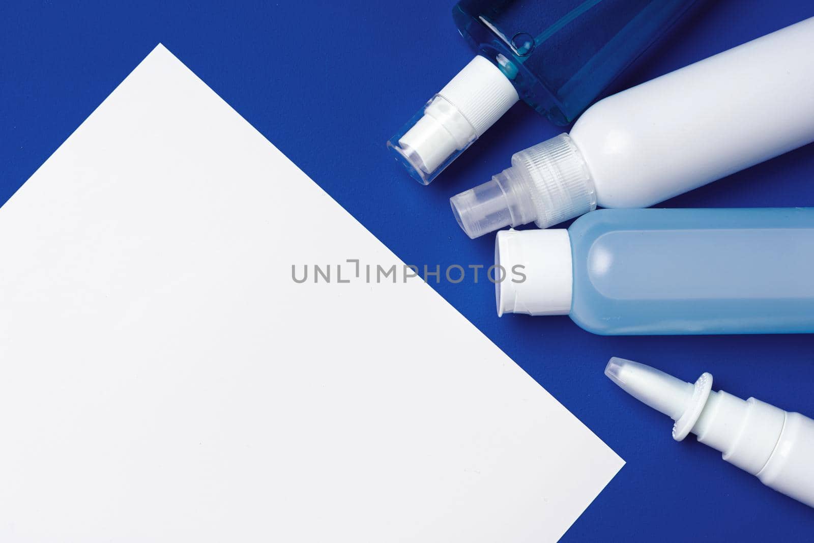 Bottles with antibacterial hand sanitizer on blue background with copy space close up