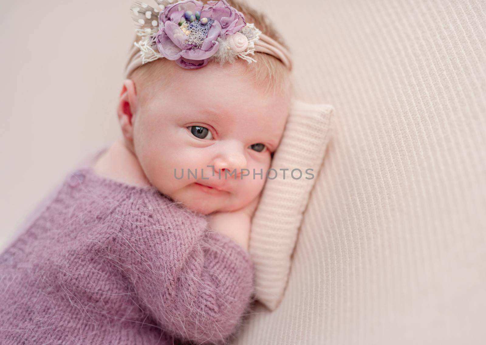 Awake newborn girl with flower diadem by tan4ikk1
