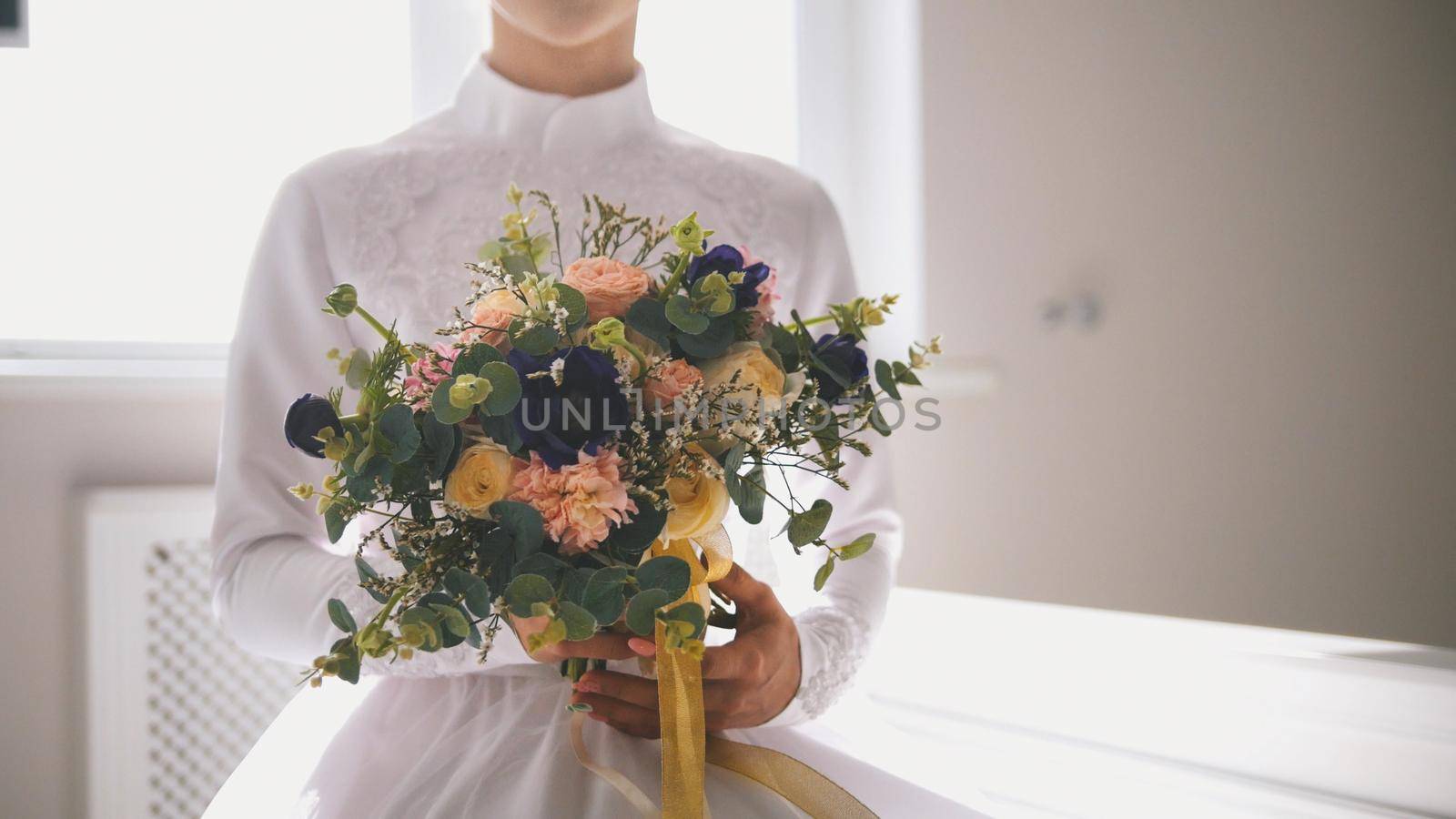 Beautiful muslim bride holding bouquet of flowers in hands, close up