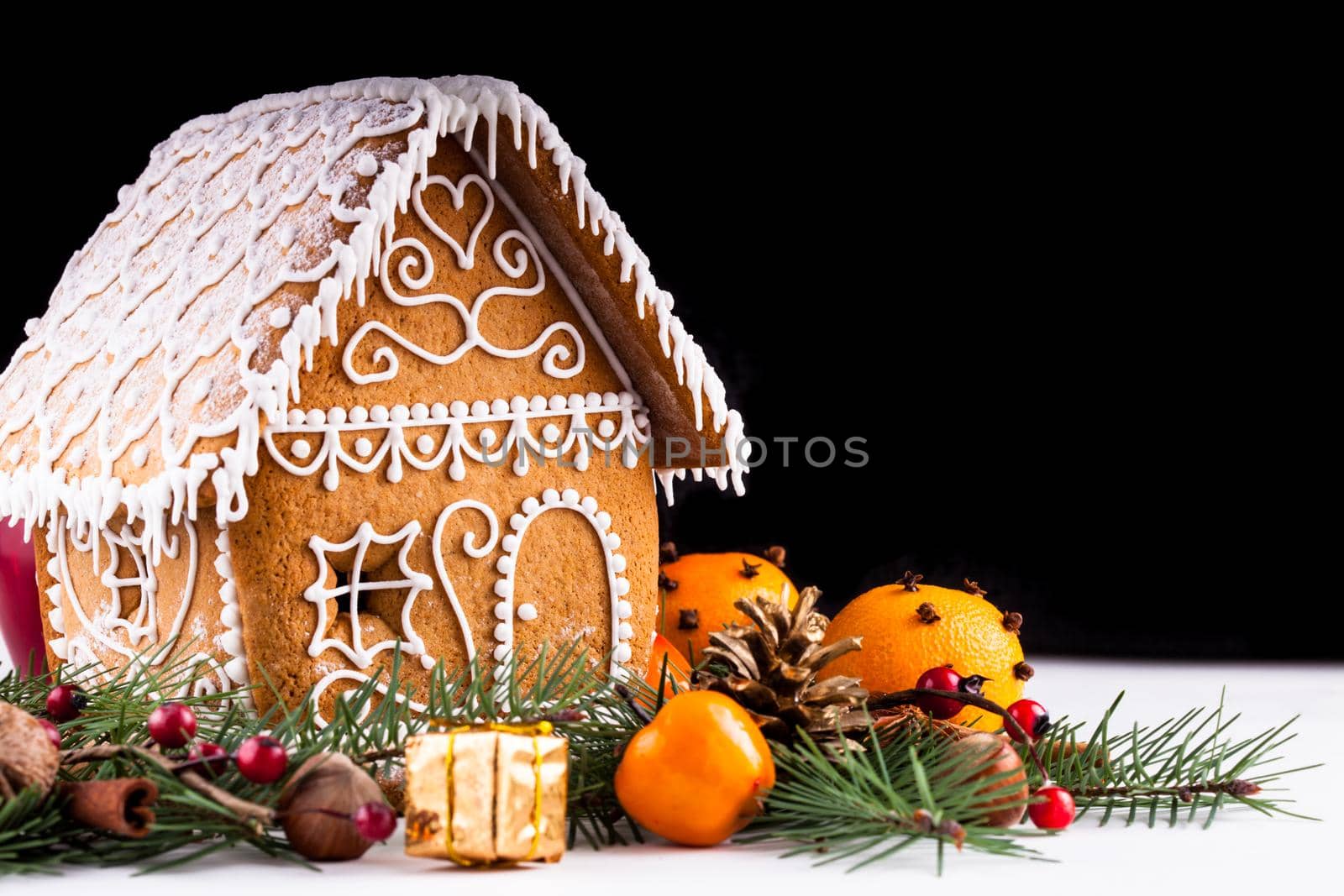 gingerbread house with christmas decorations on a white backgrond