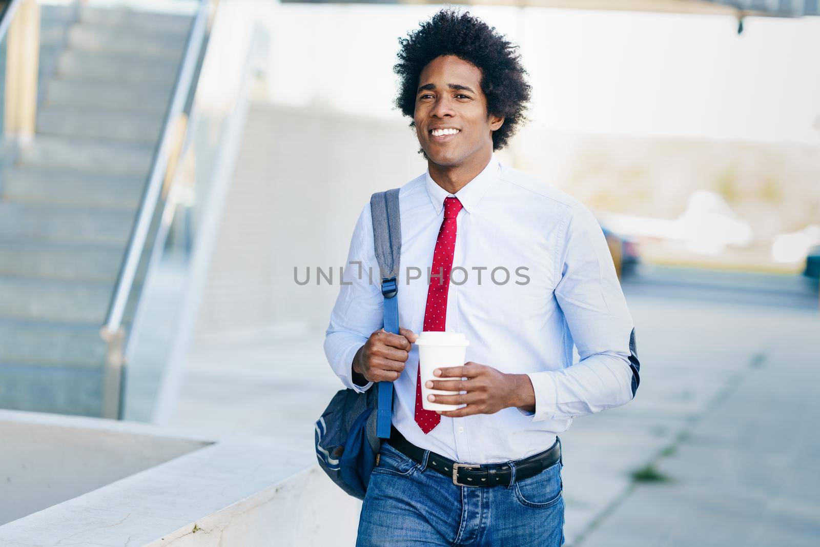 Smiling Black Businessman with a take-away glass. by javiindy