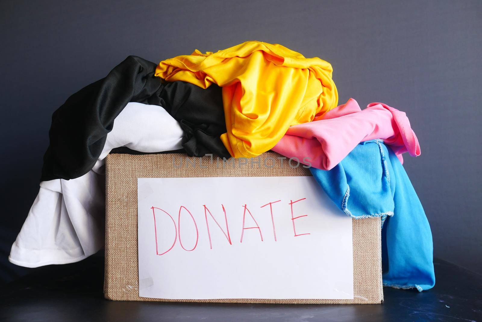 Donation box with donation clothes on a wooden background