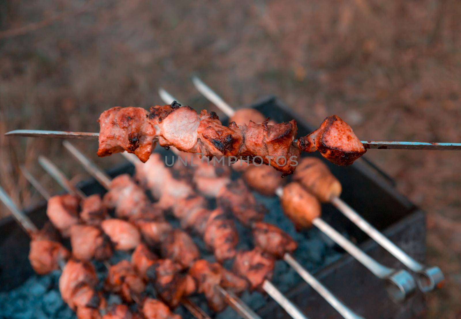 Man frying shish kebab on the grill. Hands closeup outdoors