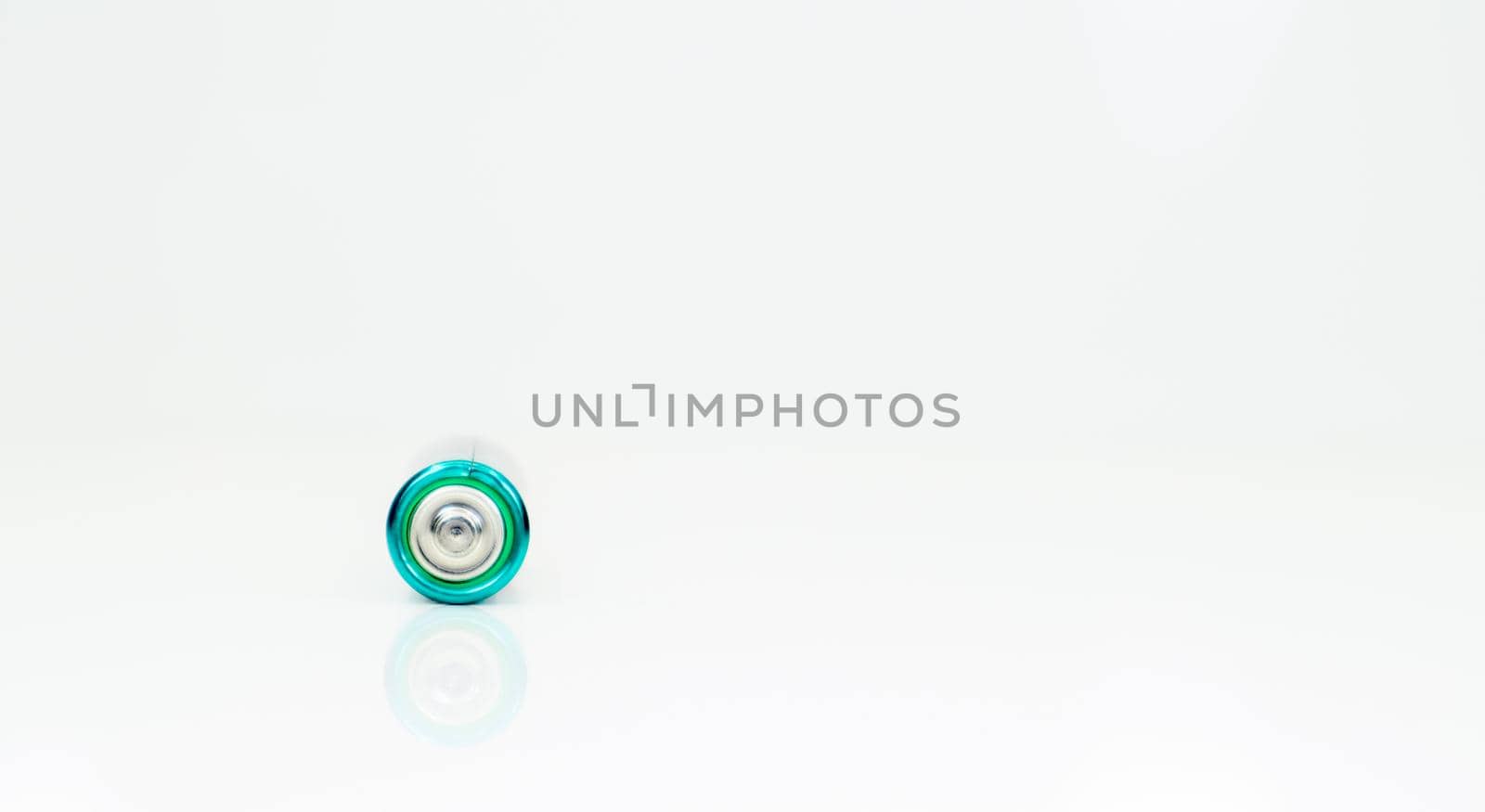 One alkaline battery on a white background with reflection. Energy supply and recycling concept. Copy space. Minimalism. Eliment AA is the most common type of galvanic batteries and accumulators