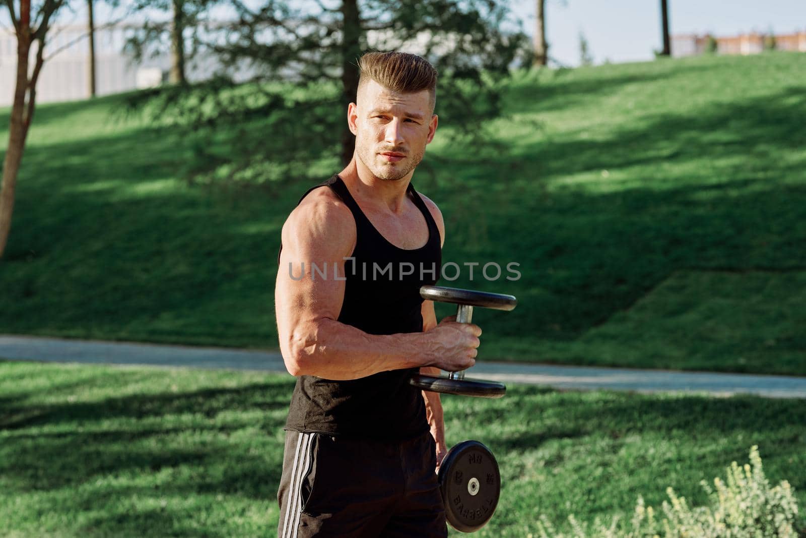 pumped up sports Vykhino in the park with dumbbell workout. High quality photo