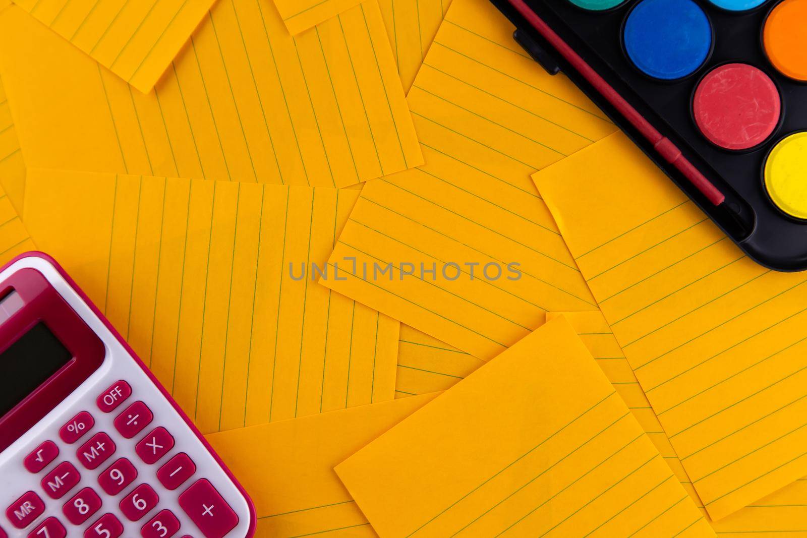 School office supplies stationery on a orange paper background with copy space. Back to school concept by lunarts